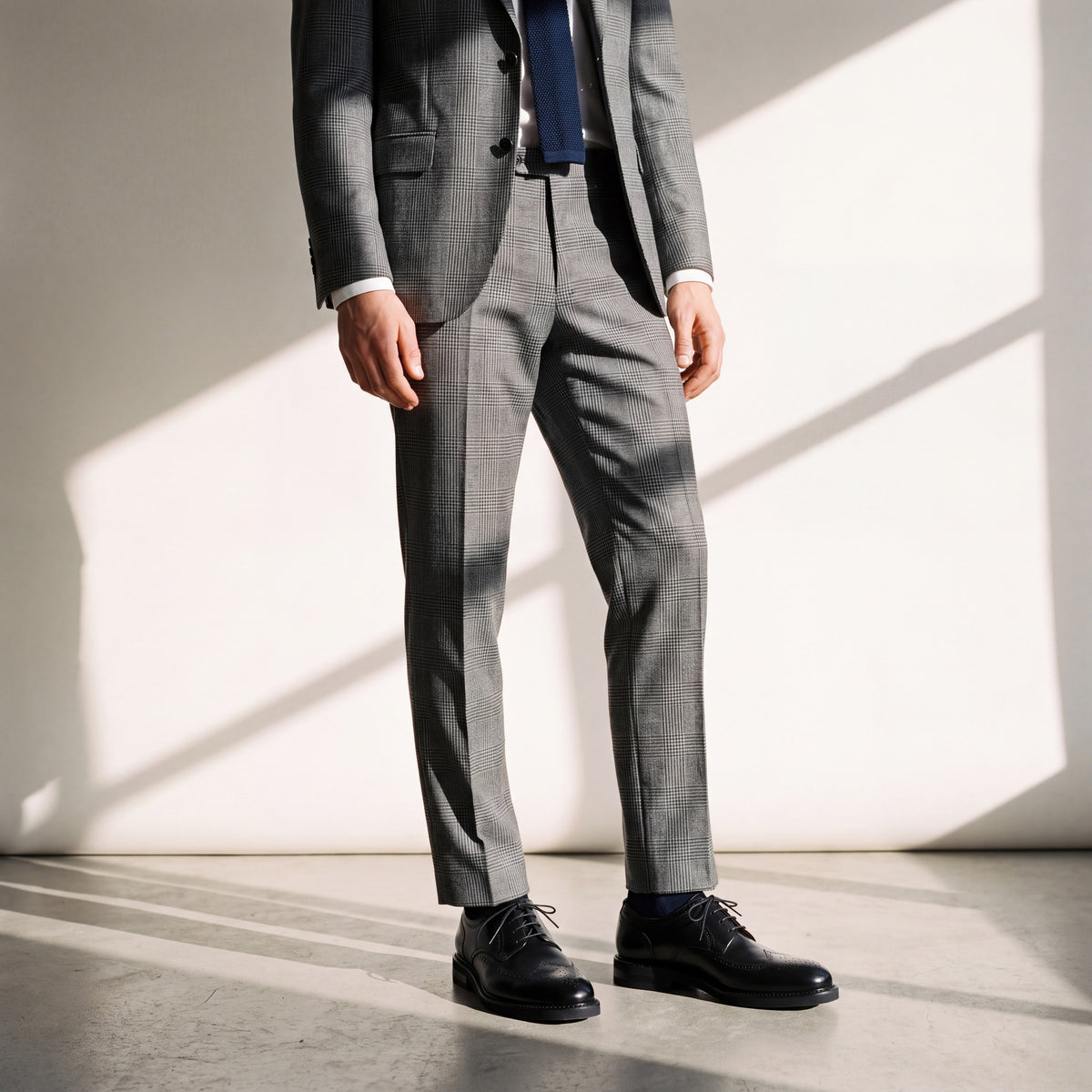 VOYAGE negro puesto con traje príncipe de Gales y corbata tejida azul marino