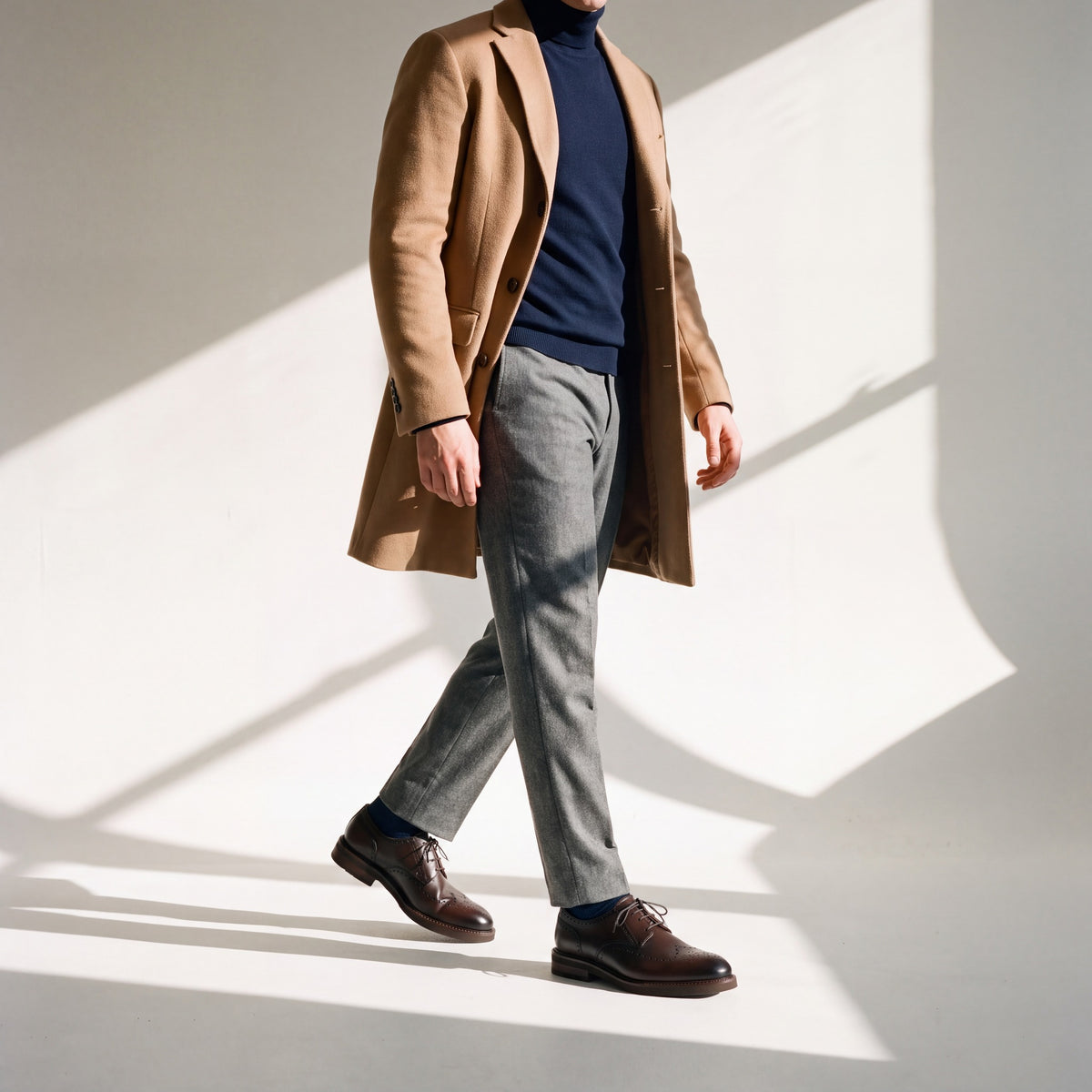 VOYAGE London puesto con abrigo camel, cuello alto azul marino y pantalón de franela gris