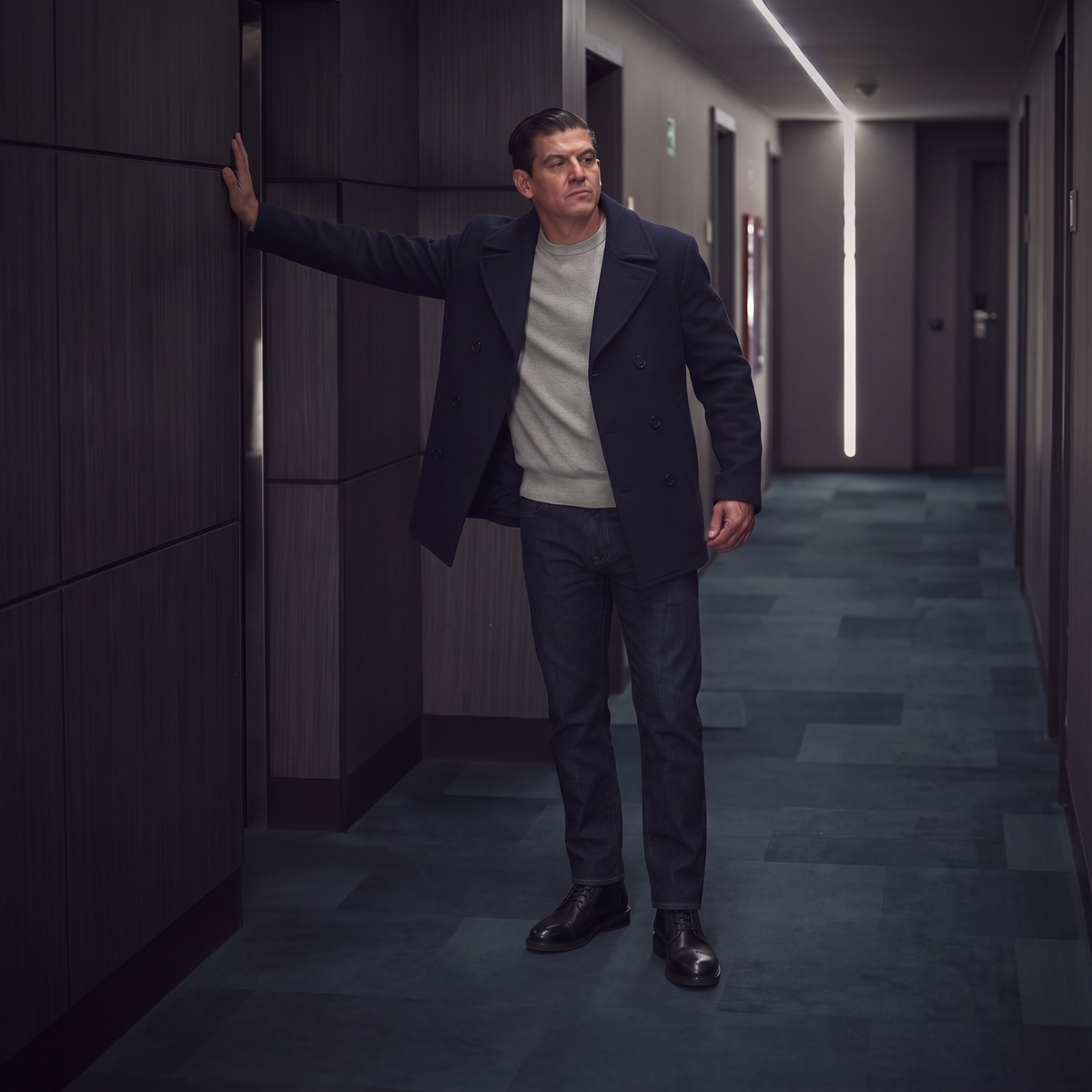 ODISEA negro puesta con peacoat azul marino, suéter gris y jeans oscuros