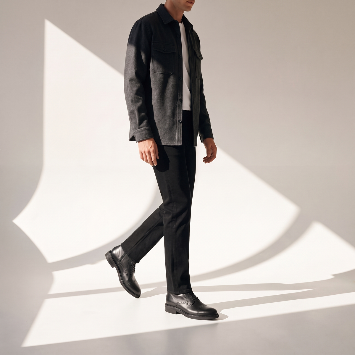 ODISEA negro puesta con sobrecamisa gris, playera blanca y jeans negros